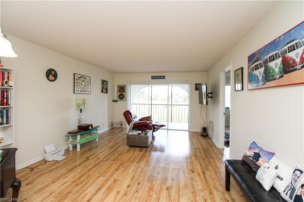 41 High Point Circle South, Unit 303 Naples, FL 34103 - Photo 14 of 39 a living room with furniture and a wooden floor