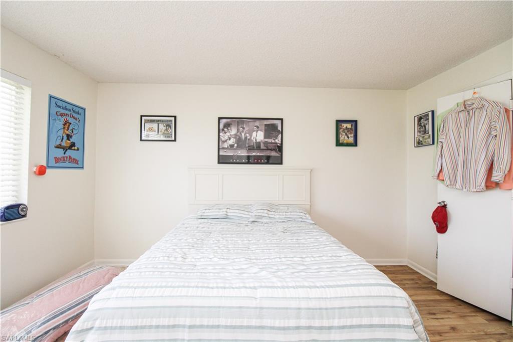 41 High Point Circle South, Unit 303 Naples, FL 34103 - Photo 21 of 39 a bedroom with bed and wall painting