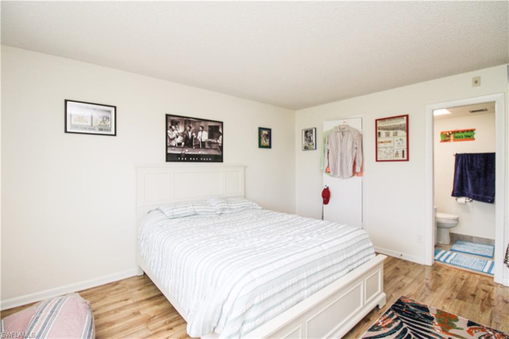 41 High Point Circle South, Unit 303 Naples, FL 34103 - Photo 22 of 39 a bedroom with a bed and a flat screen tv