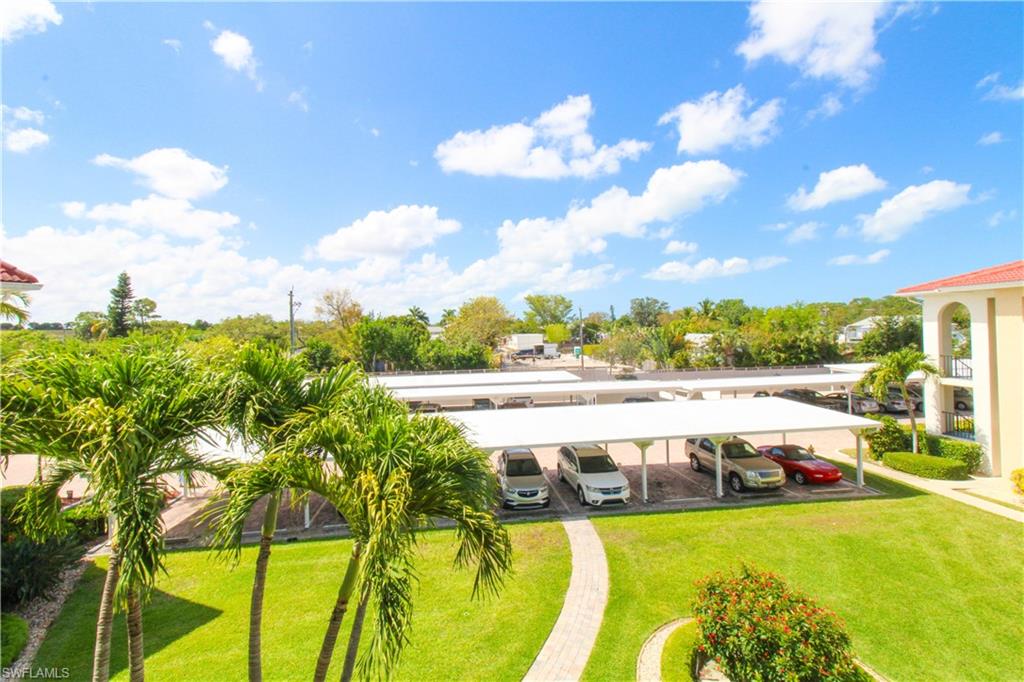 41 High Point Circle South, Unit 303 Naples, FL 34103 - Photo 29 of 39 a view of a swimming pool with an outdoor seating and a yard