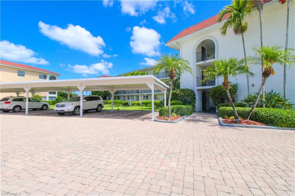 41 High Point Circle South, Unit 303 Naples, FL 34103 - Photo 35 of 39 a view of a house with a yard and potted plants