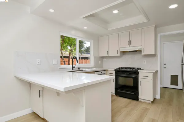 a kitchen with white cabinets and a stove