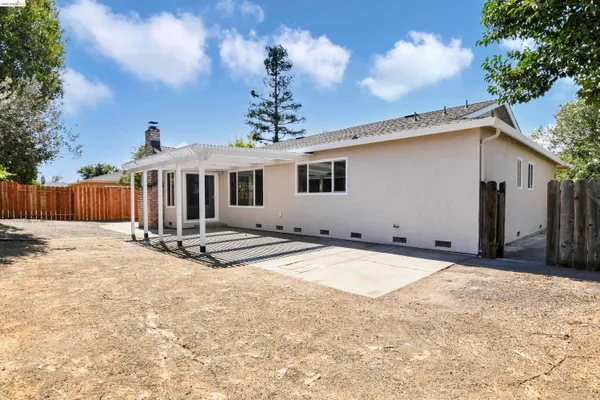 a view of a house with backyard and a tree