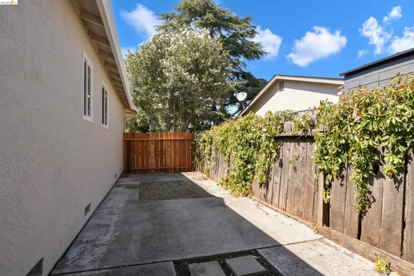 a view of a pathway of a house with wooden fence