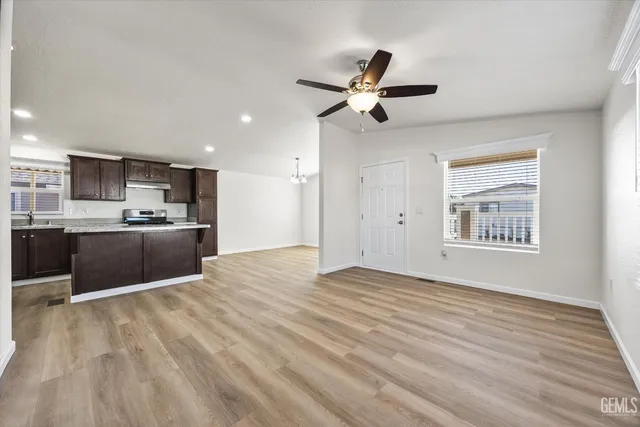 a view of kitchen and empty room with wooden floor