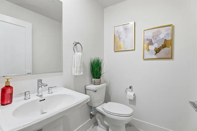 a bathroom with a sink mirror and toilet
