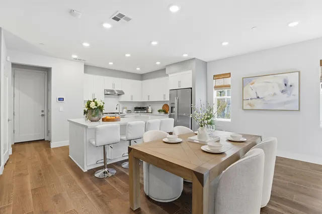 a kitchen with a sink dining table and chairs