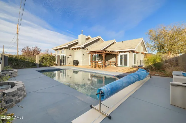 a view of a house with pool and chairs