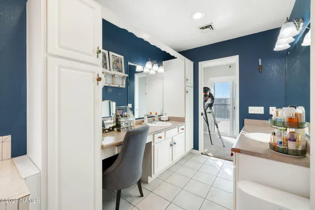 a spacious bathroom with a large mirror a bathtub and a chandelier