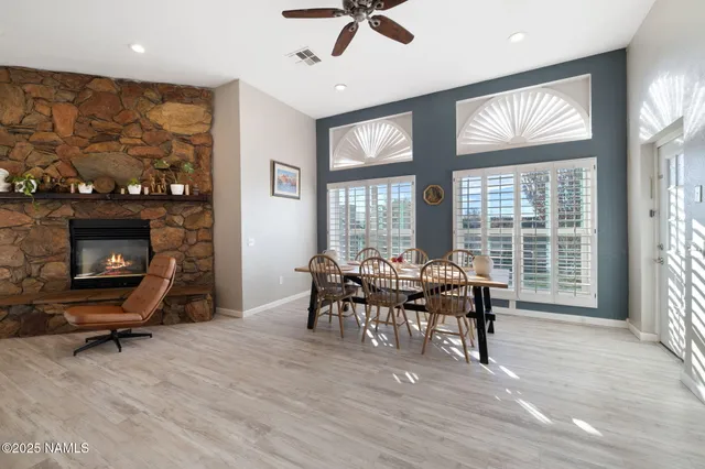 a kitchen with stainless steel appliances kitchen island granite countertop a table chairs refrigerator and a sink