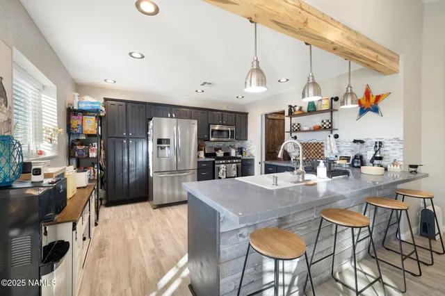 a kitchen with stainless steel appliances granite countertop a refrigerator stove and sink