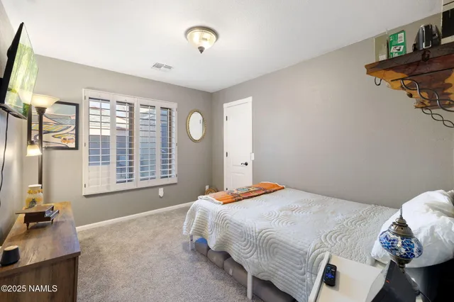 a bedroom with a bed next to a window