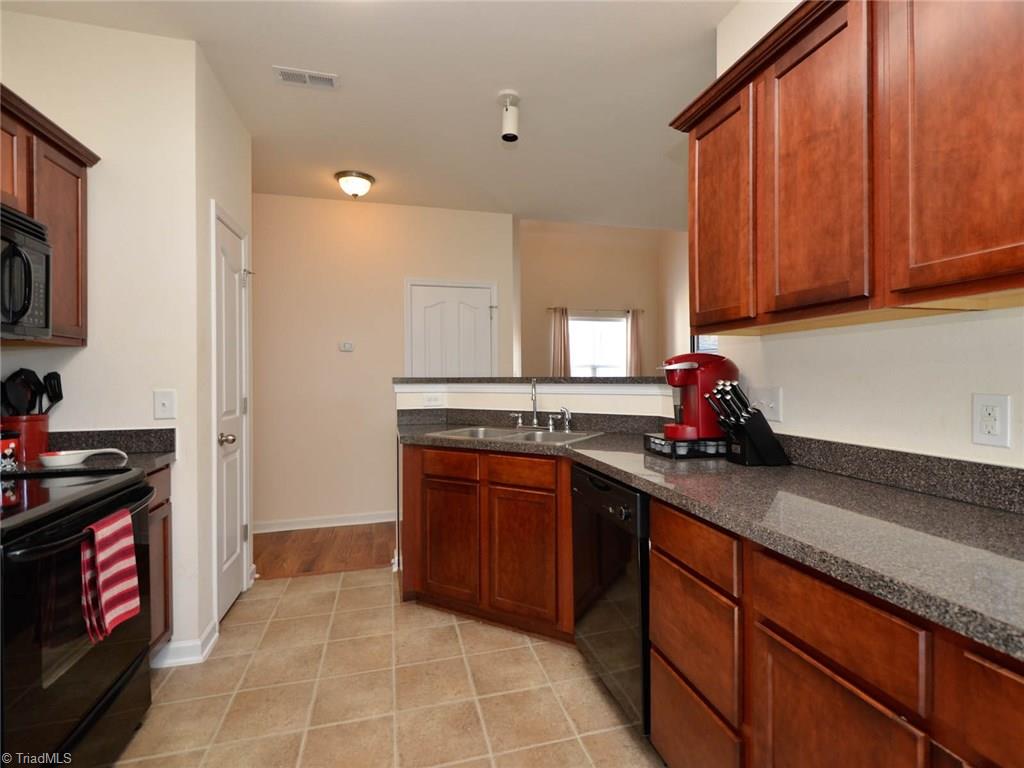 815 Hartley Hill Court High Point, NC 27265 - Photo 7 of 23 Kitchen with plenty of cabinetry, granite counters and black appliances.