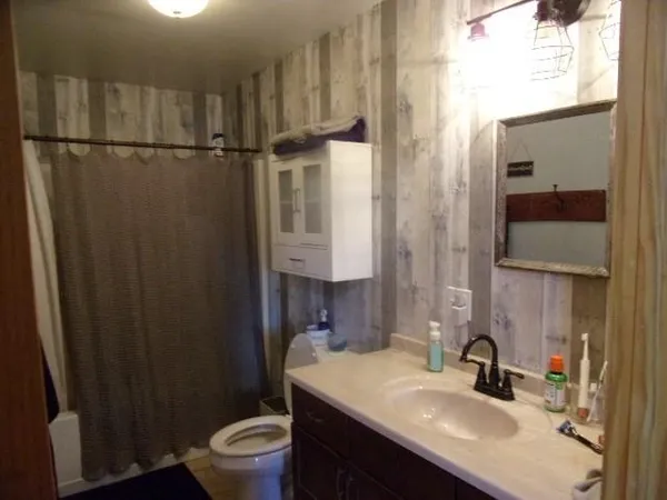 a bathroom with a sink toilet and shower