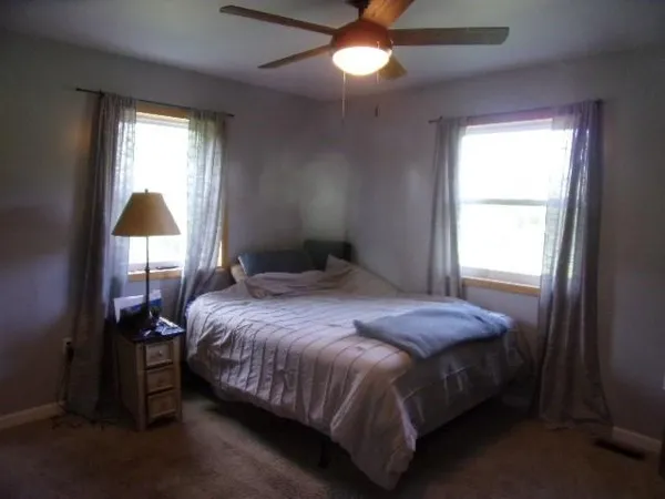 a bedroom with a bed and a window