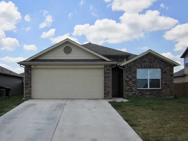 A well-maintained facade with brick accents and a two-car garage awaits.