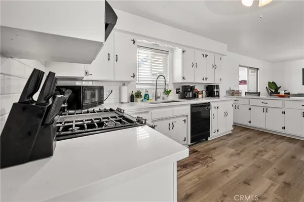 a kitchen with stainless steel appliances granite countertop a refrigerator a stove and a sink