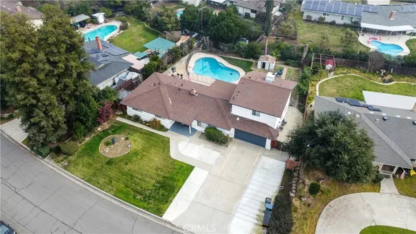 an aerial view of a house with a swimming pool and outdoor seating