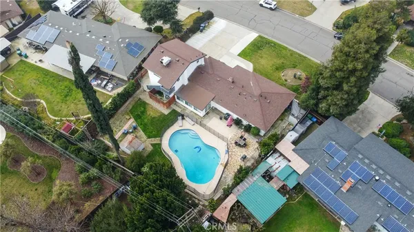 an aerial view of a house with a swimming pool and outdoor seating