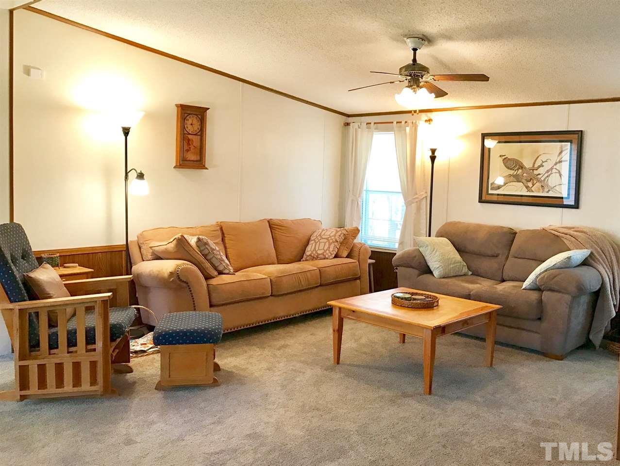 6916 Matthews Road Durham, NC 27712 - Photo 5 of 24 a living room with furniture and a chandelier