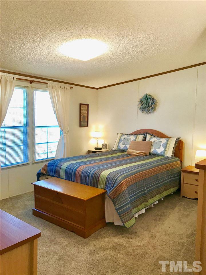 6916 Matthews Road Durham, NC 27712 - Photo 6 of 24 a bedroom with bed and window