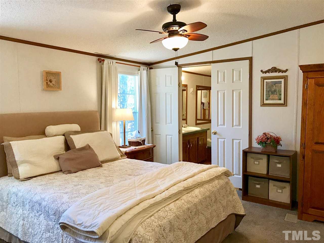 6916 Matthews Road Durham, NC 27712 - Photo 10 of 24 a bedroom with a bed and a chandelier