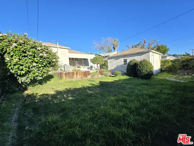 a view of a house with a big yard and large trees