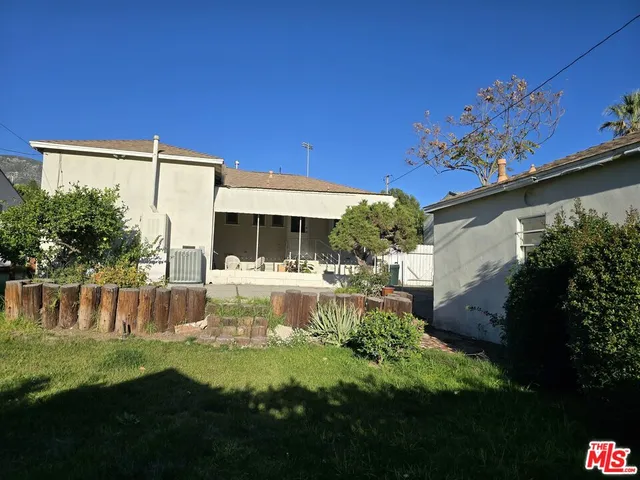 a view of a house with backyard and sitting area