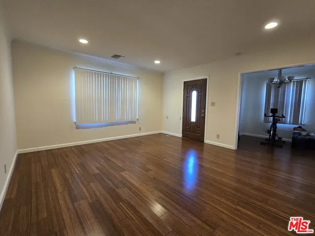 a view of a livingroom with wooden floor and stairs
