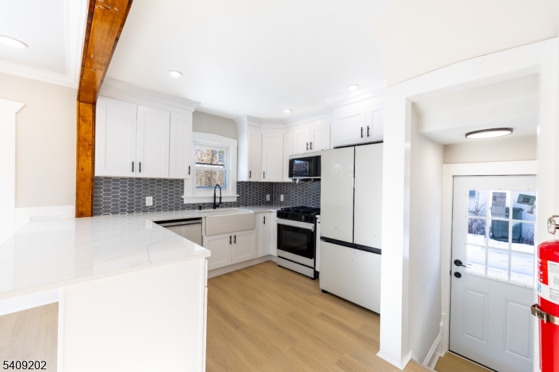 431 North Main Street Wharton, NJ 07885 - Photo 9 of 47 a kitchen with a refrigerator a stove top oven and white cabinets