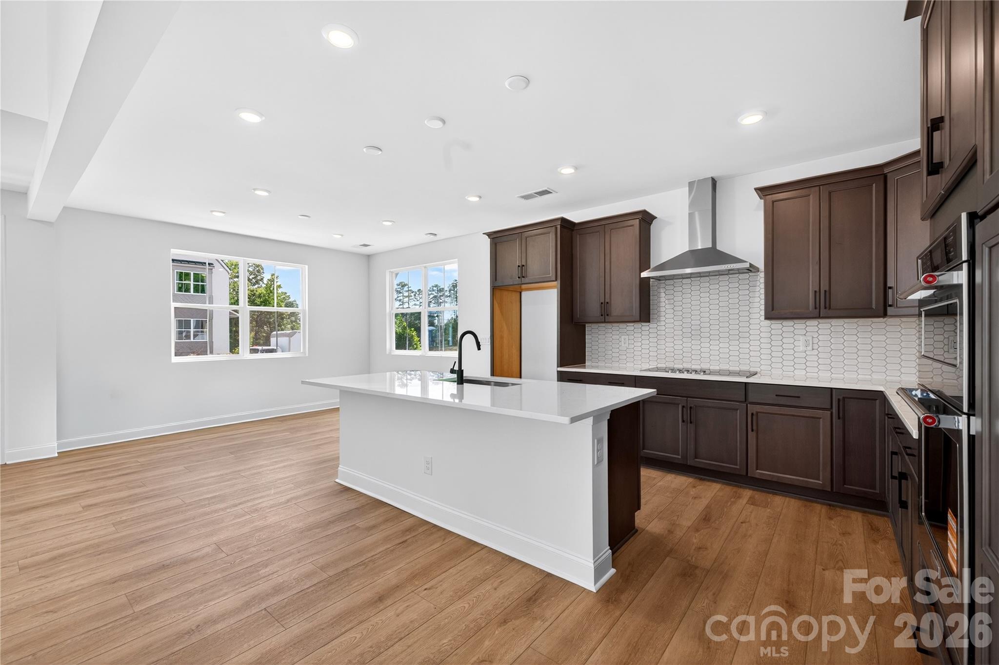 409 Celestial Drive Tega Cay, SC 29708 - Photo 3 of 10 a kitchen with stainless steel appliances granite countertop a refrigerator a sink dishwasher a stove and white countertops with wooden floor
