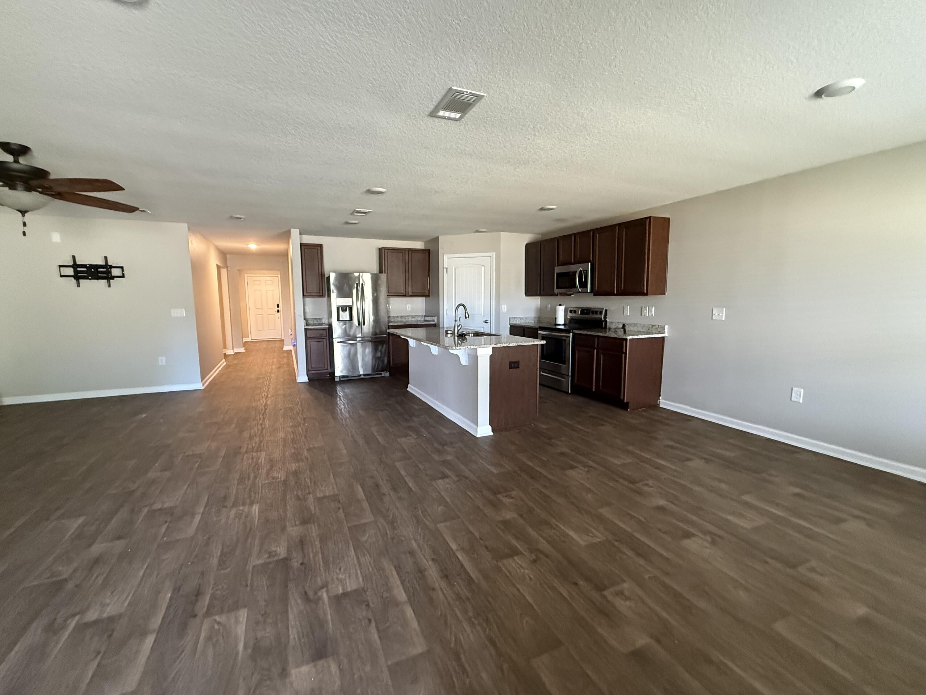 1004 Limpkin Street Crestview, FL 32539 - Photo 11 of 31 a view of kitchen with microwave a stove and wooden floor