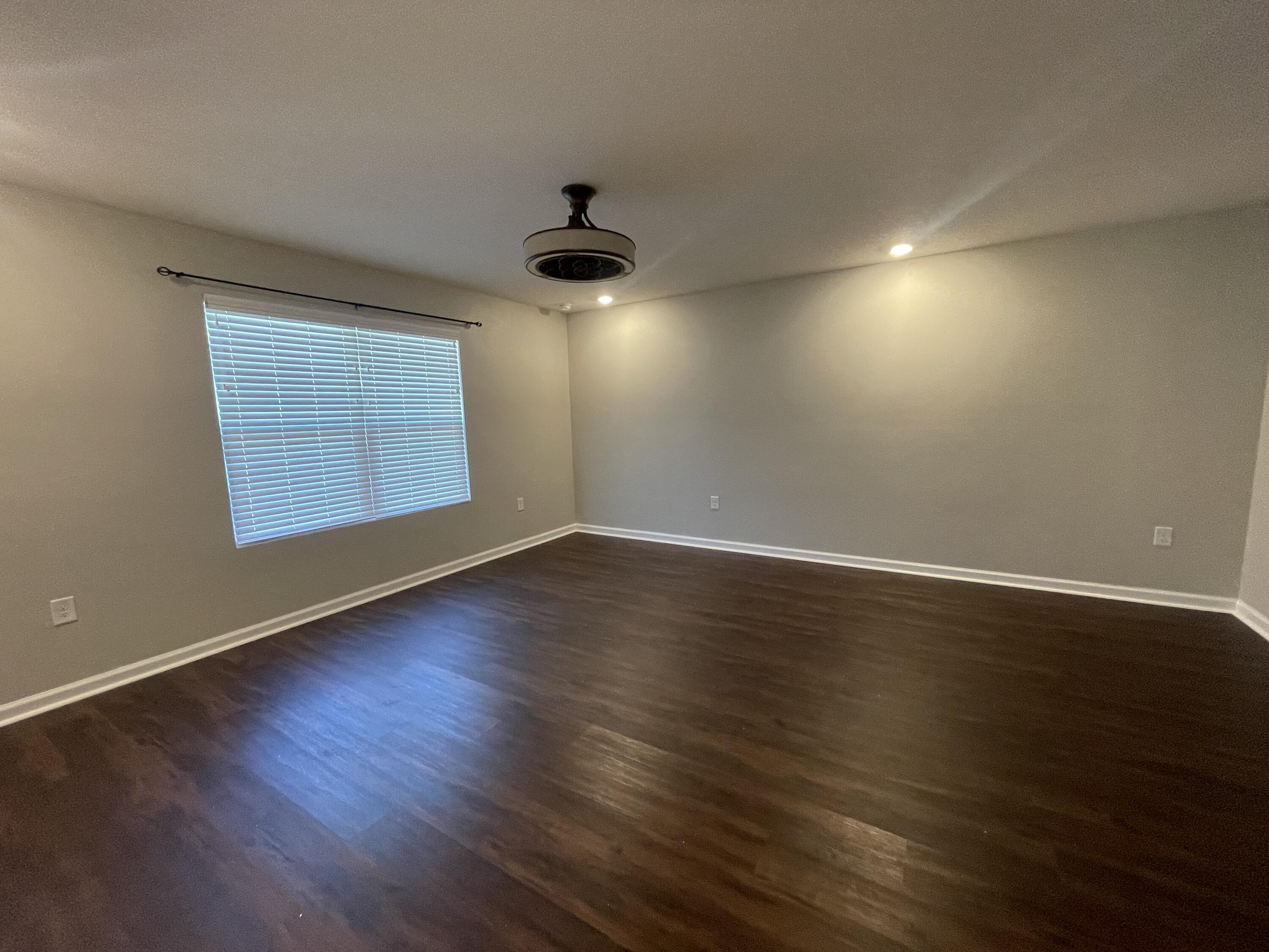 1004 Limpkin Street Crestview, FL 32539 - Photo 3 of 31 an empty room with wooden floor and windows