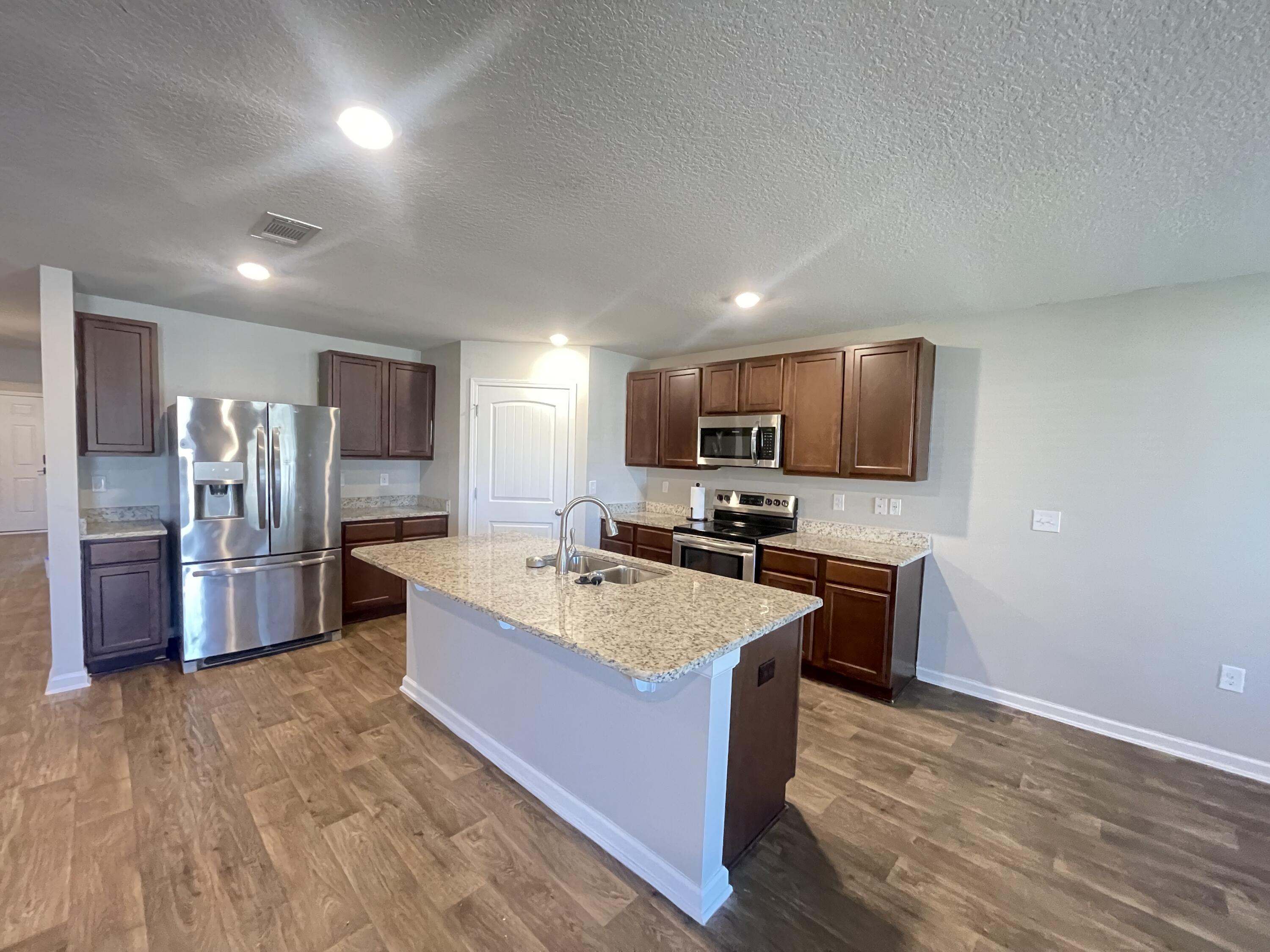 1004 Limpkin Street Crestview, FL 32539 - Photo 7 of 31 a large kitchen with a large counter top appliances and cabinets