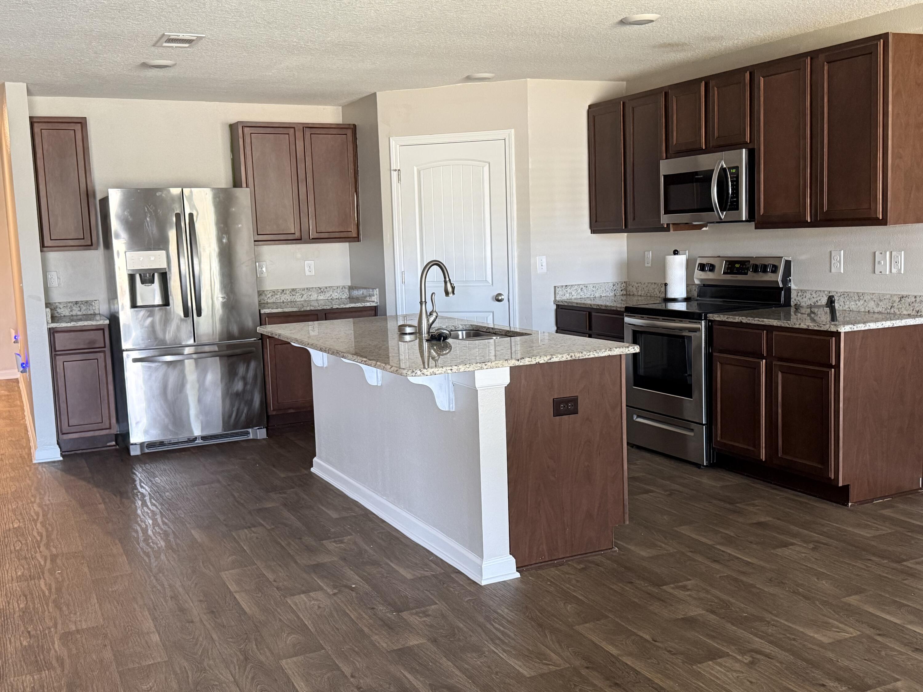 1004 Limpkin Street Crestview, FL 32539 - Photo 10 of 31 a kitchen with stainless steel appliances granite countertop a stove top oven a sink and a refrigerator