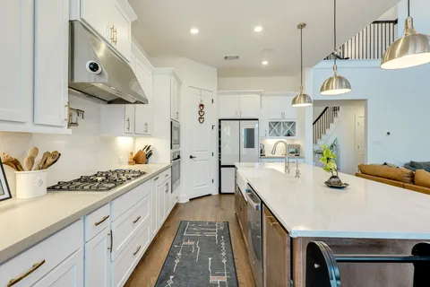 a kitchen with stainless steel appliances a stove a sink island and a refrigerator
