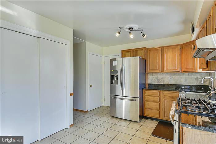 1307 Gresham Road Silver Spring, MD 20904 - Photo 7 of 22 a kitchen with stainless steel appliances granite countertop a refrigerator and a stove top oven