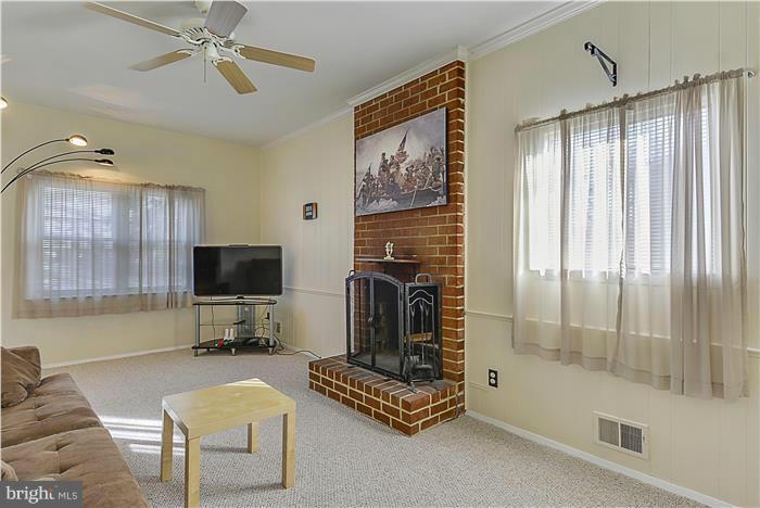 1307 Gresham Road Silver Spring, MD 20904 - Photo 10 of 22 a living room with furniture a flat screen tv and a fireplace