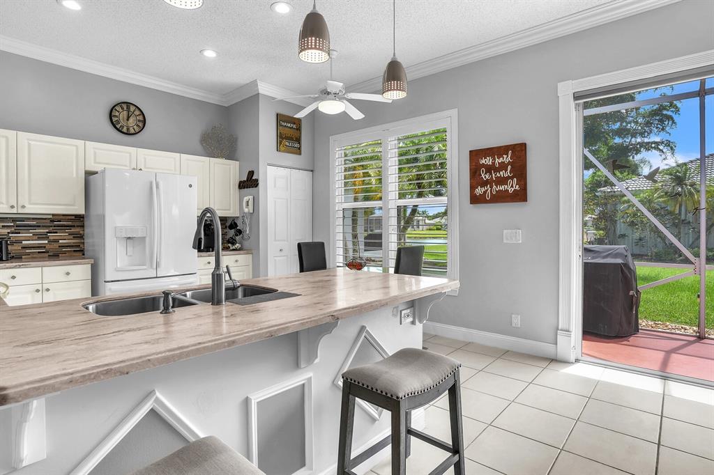 7955 Rockford Road Boynton Beach, FL 33472 - Photo 17 of 22 a kitchen with stainless steel appliances granite countertop a sink and a refrigerator