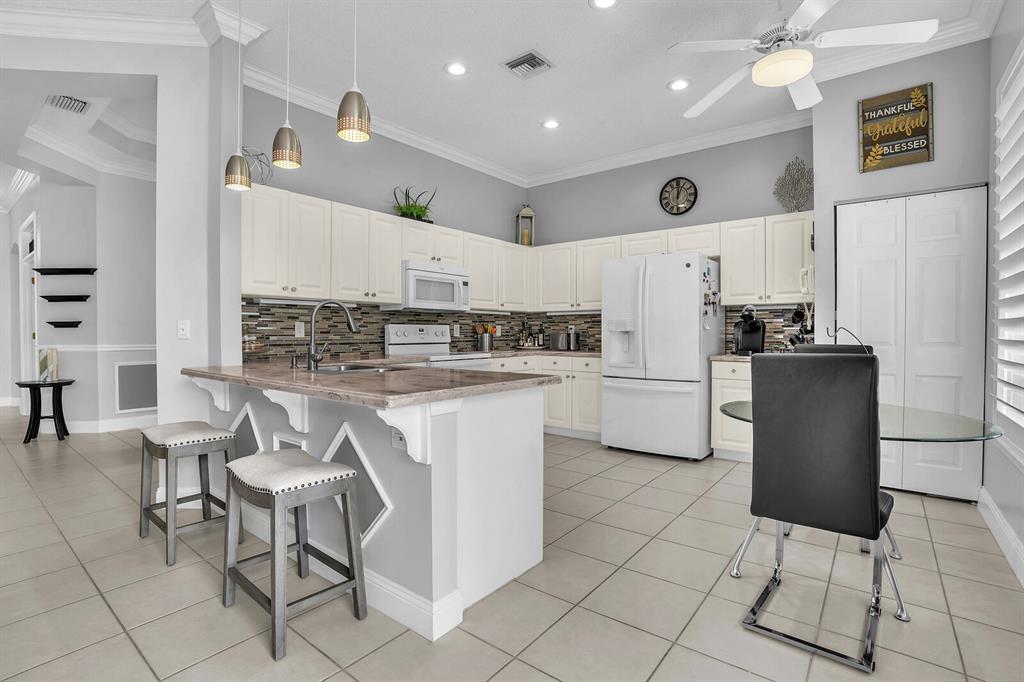 7955 Rockford Road Boynton Beach, FL 33472 - Photo 22 of 22 a kitchen with a dining table chairs and a refrigerator
