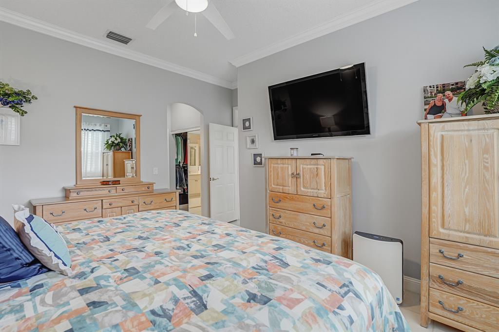 7955 Rockford Road Boynton Beach, FL 33472 - Photo 8 of 22 a bedroom with a bed and a flat screen tv in it