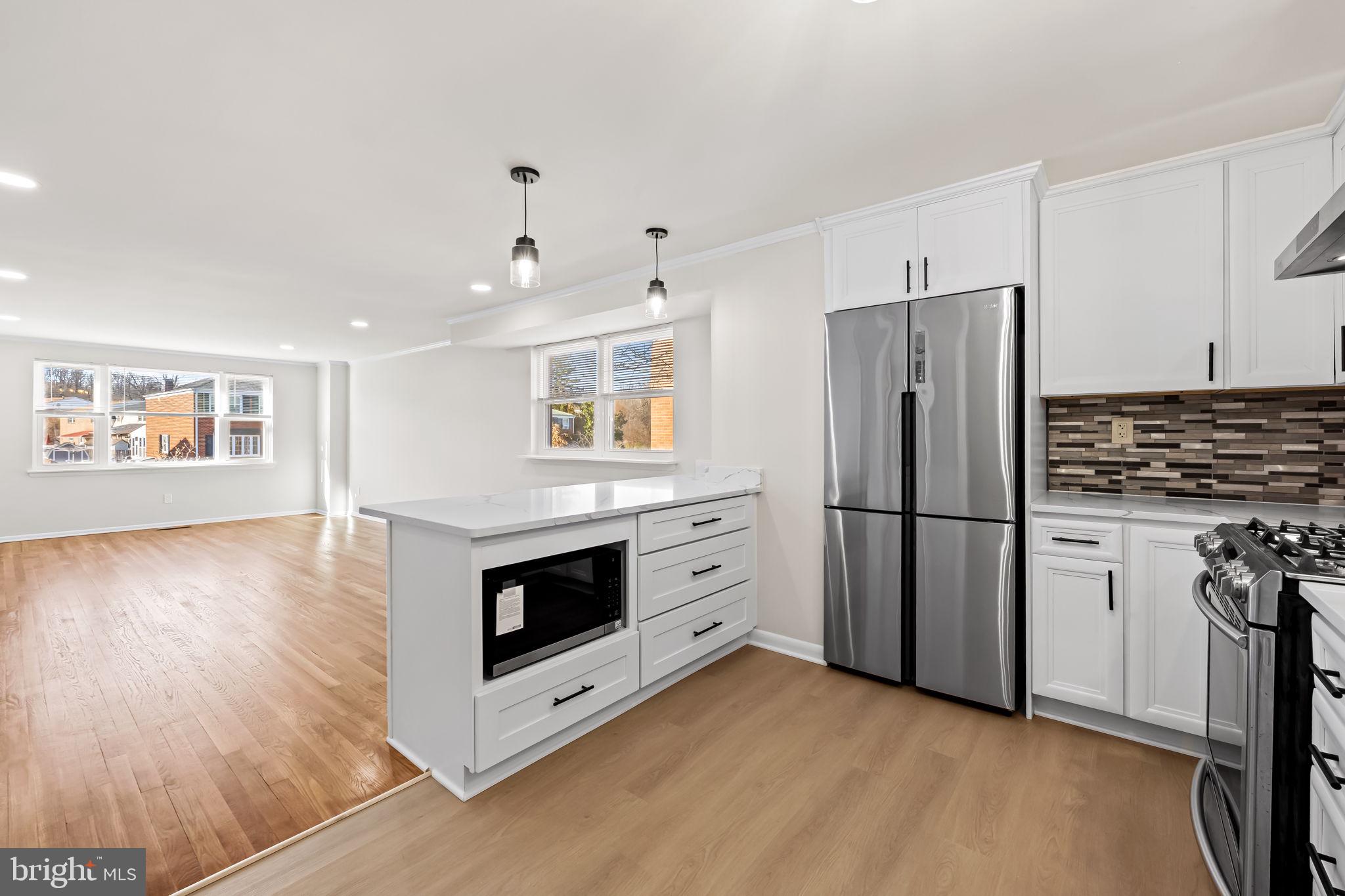 5613 Chelwynd Road Baltimore, MD 21227 - Photo 11 of 38 a kitchen with a refrigerator and a stove top oven