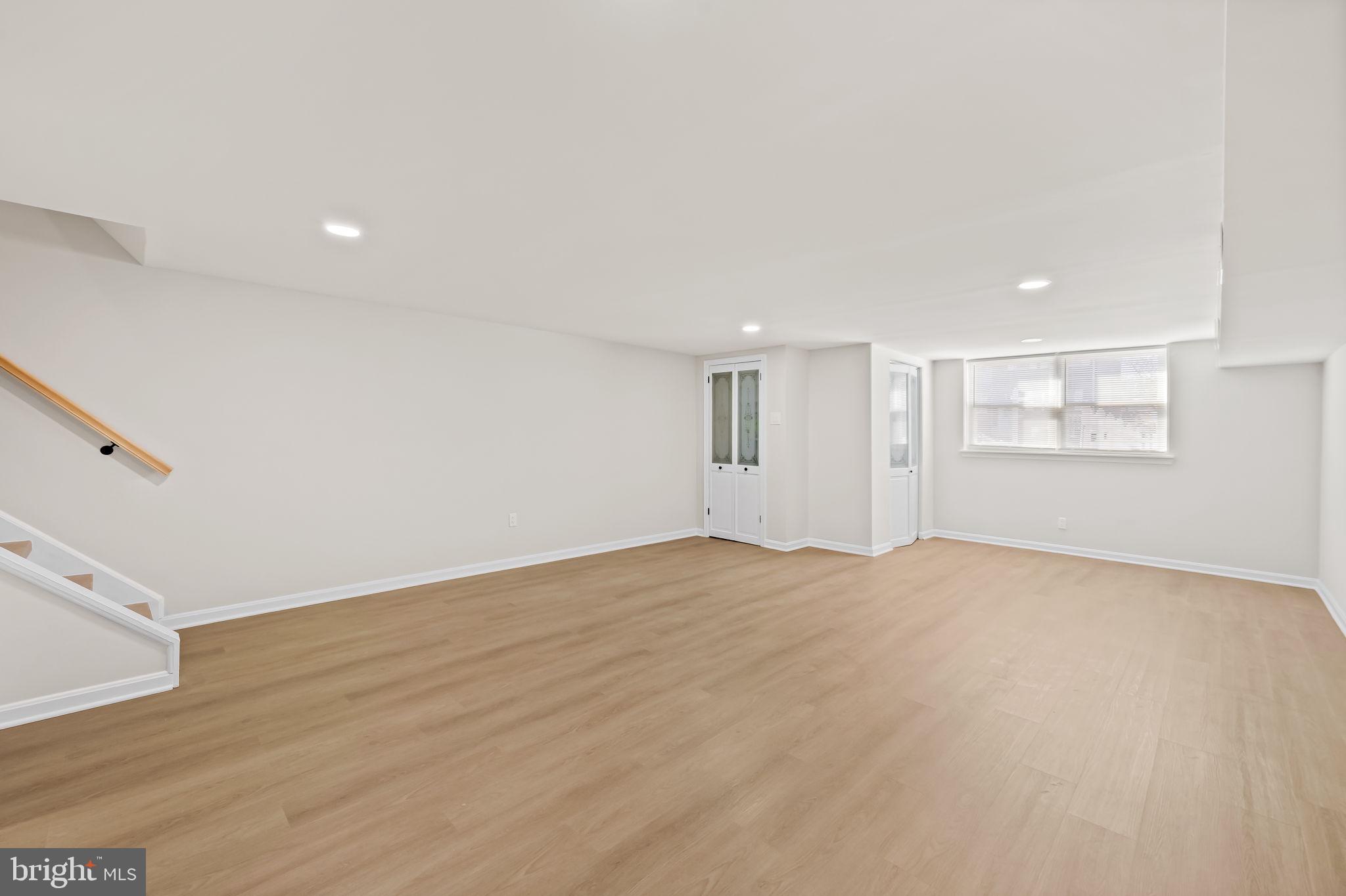 5613 Chelwynd Road Baltimore, MD 21227 - Photo 17 of 38 a view of an empty room with wooden floor and a window