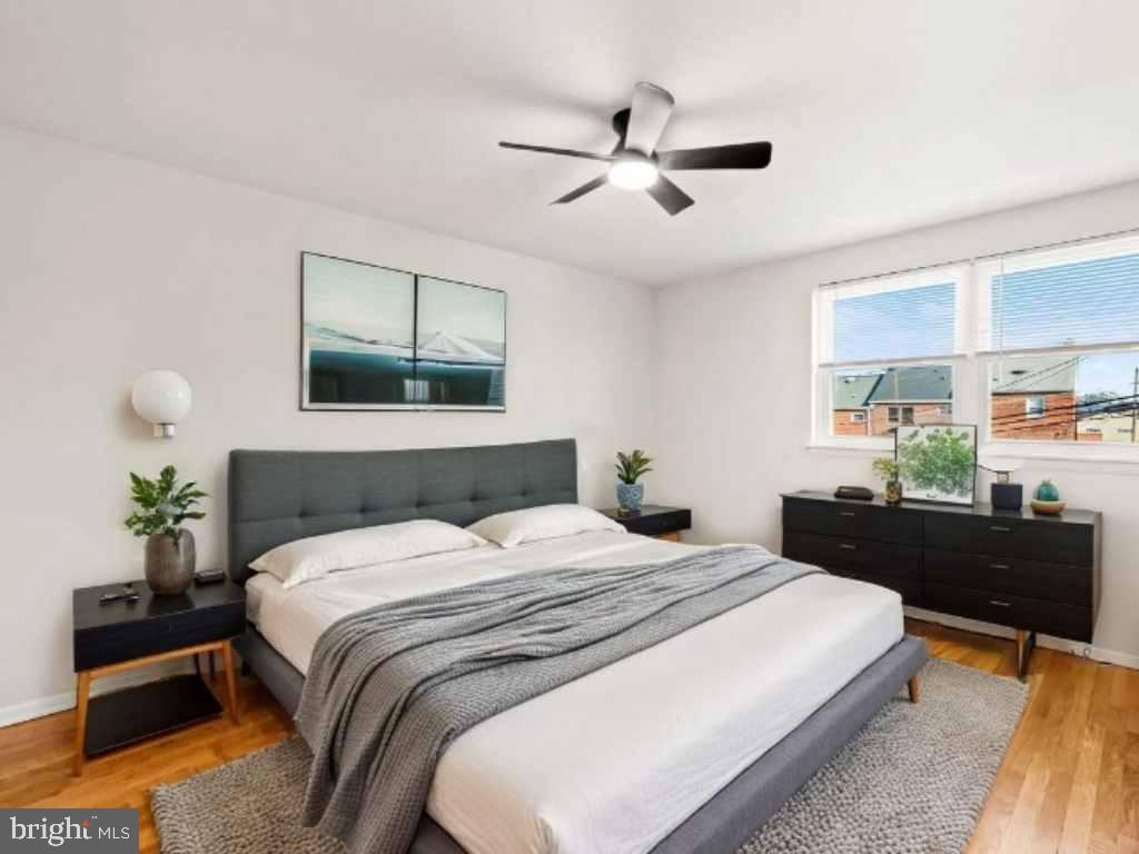 5613 Chelwynd Road Baltimore, MD 21227 - Photo 20 of 38 a bedroom with a bed a dresser and a potted plant