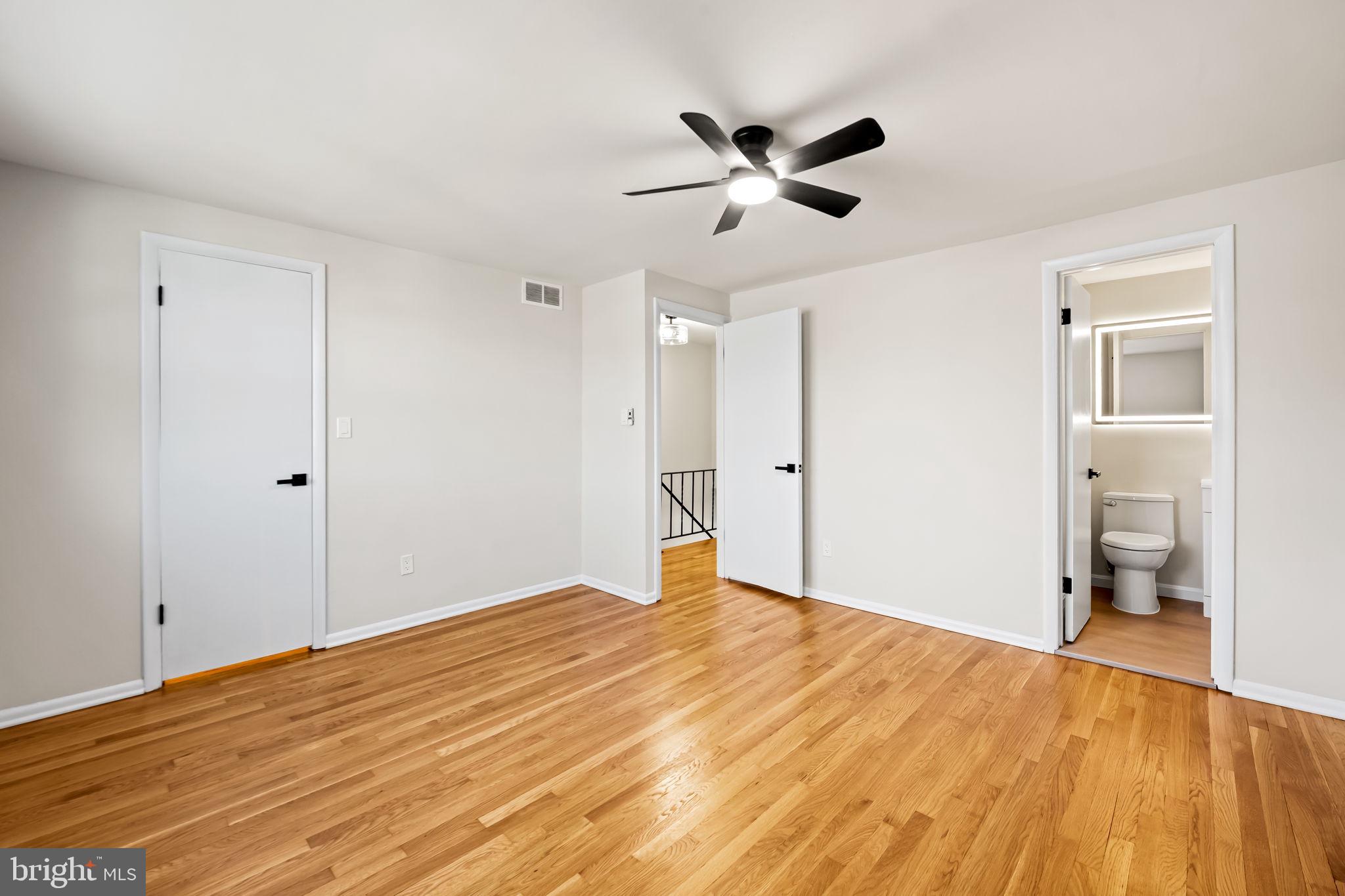 5613 Chelwynd Road Baltimore, MD 21227 - Photo 22 of 38 a view of empty room with wooden floor and ceiling fan