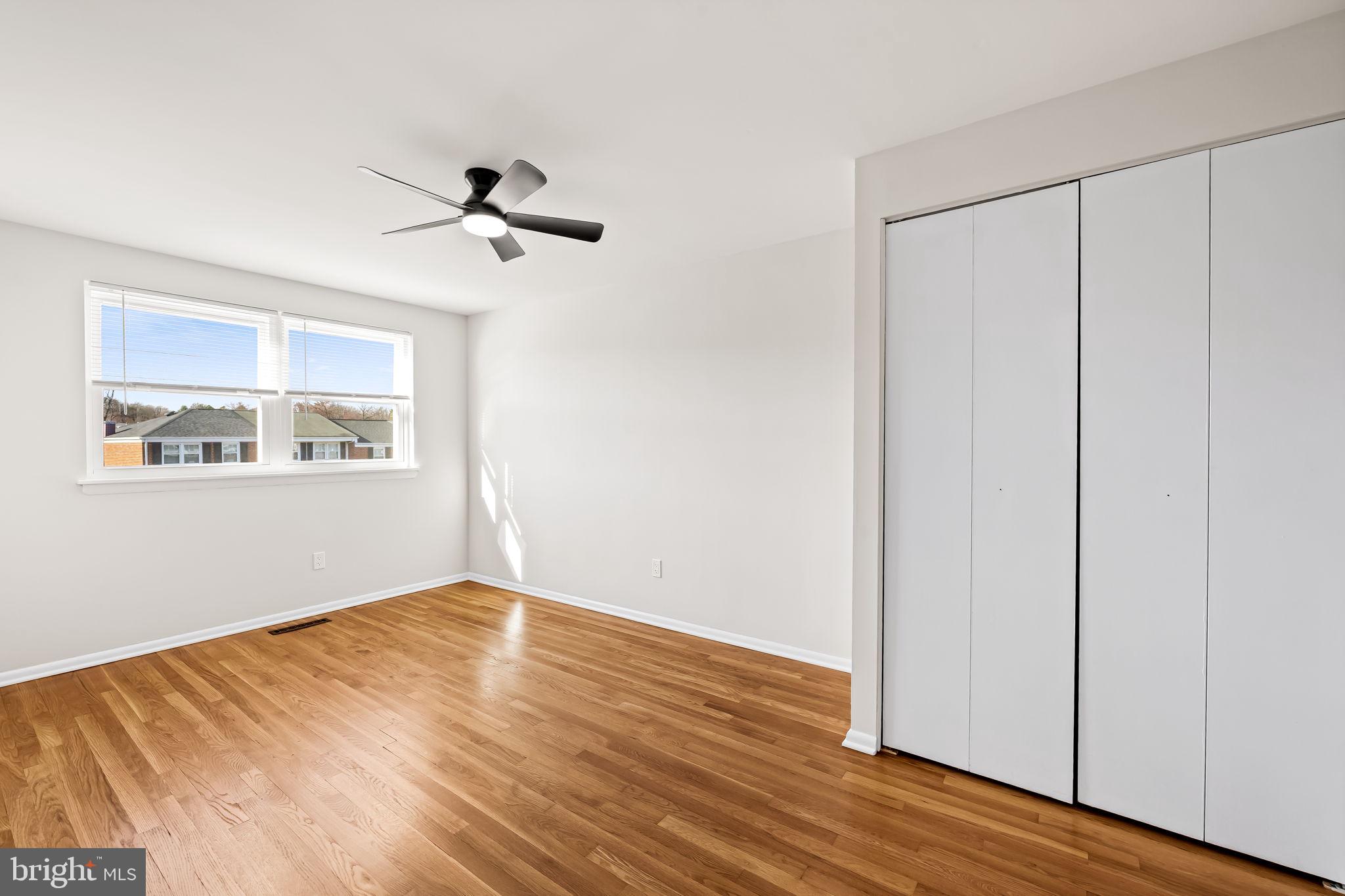 5613 Chelwynd Road Baltimore, MD 21227 - Photo 29 of 38 a view of empty room with wooden floor and fan