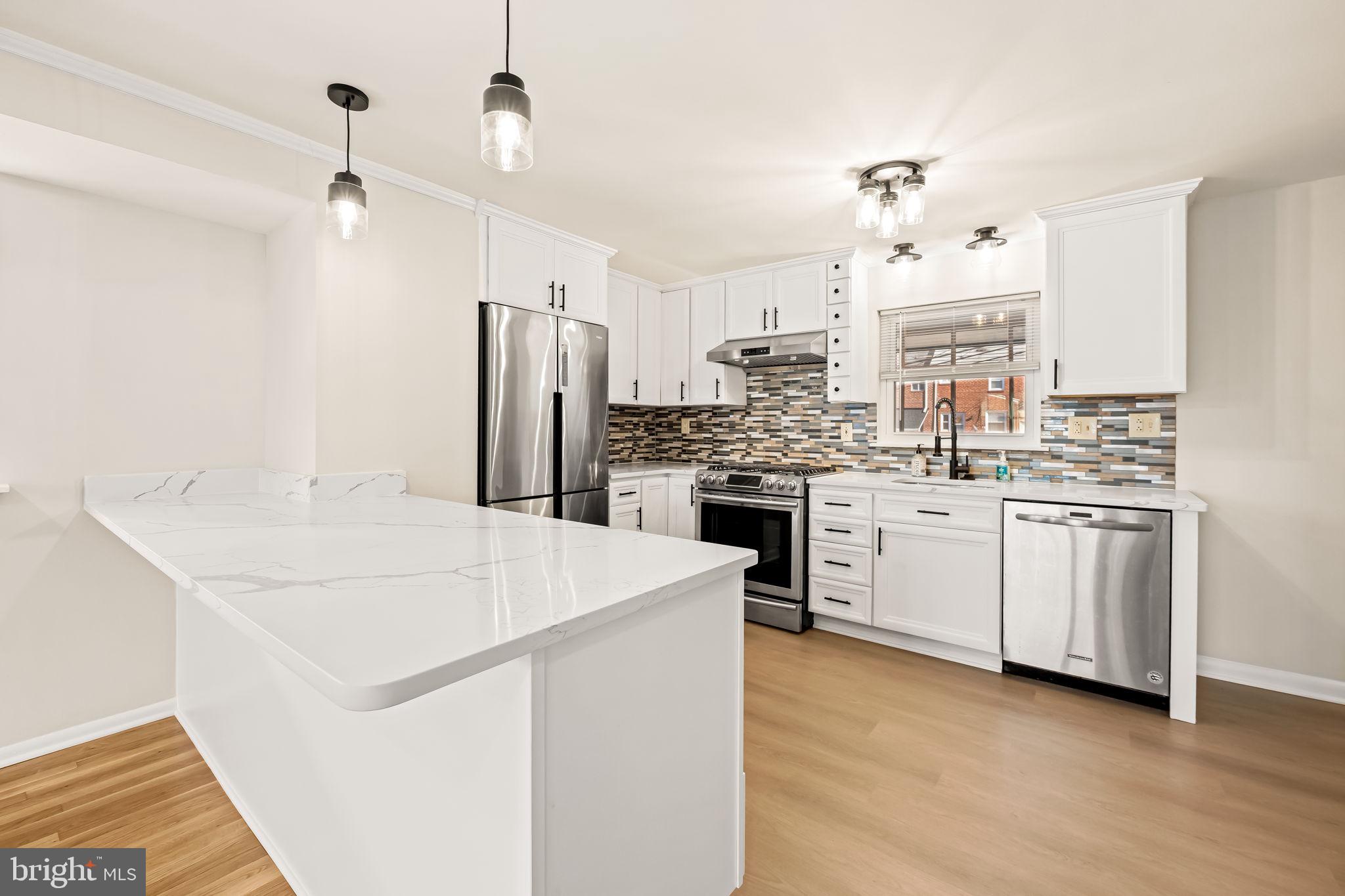 5613 Chelwynd Road Baltimore, MD 21227 - Photo 9 of 38 a kitchen with white cabinets and white appliances