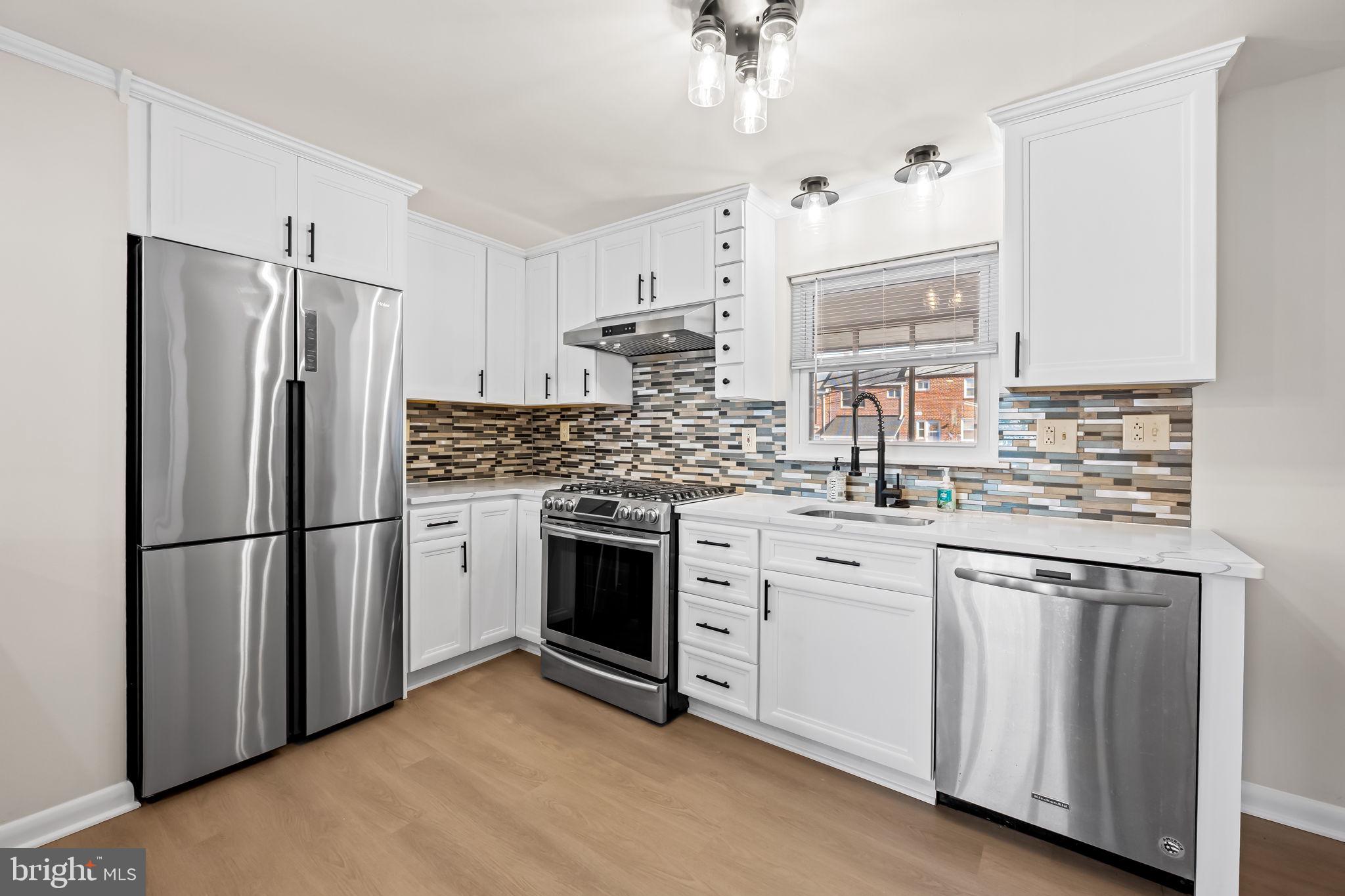 5613 Chelwynd Road Baltimore, MD 21227 - Photo 10 of 38 a kitchen with white cabinets and white appliances