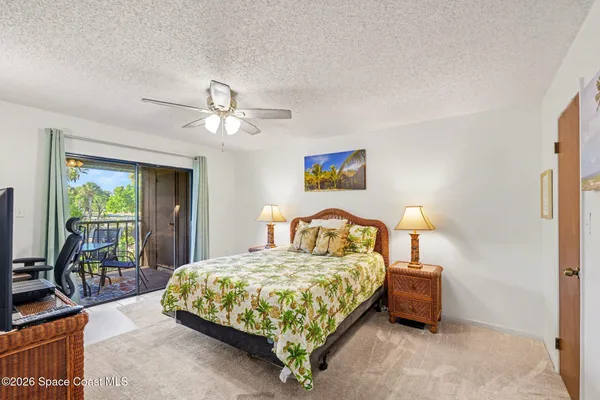 a bedroom with a bed a couch and a chandelier