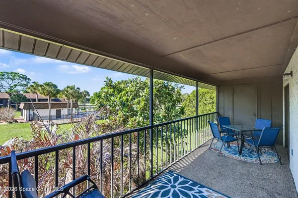 a view of a chairs and table in patio with wooden fence